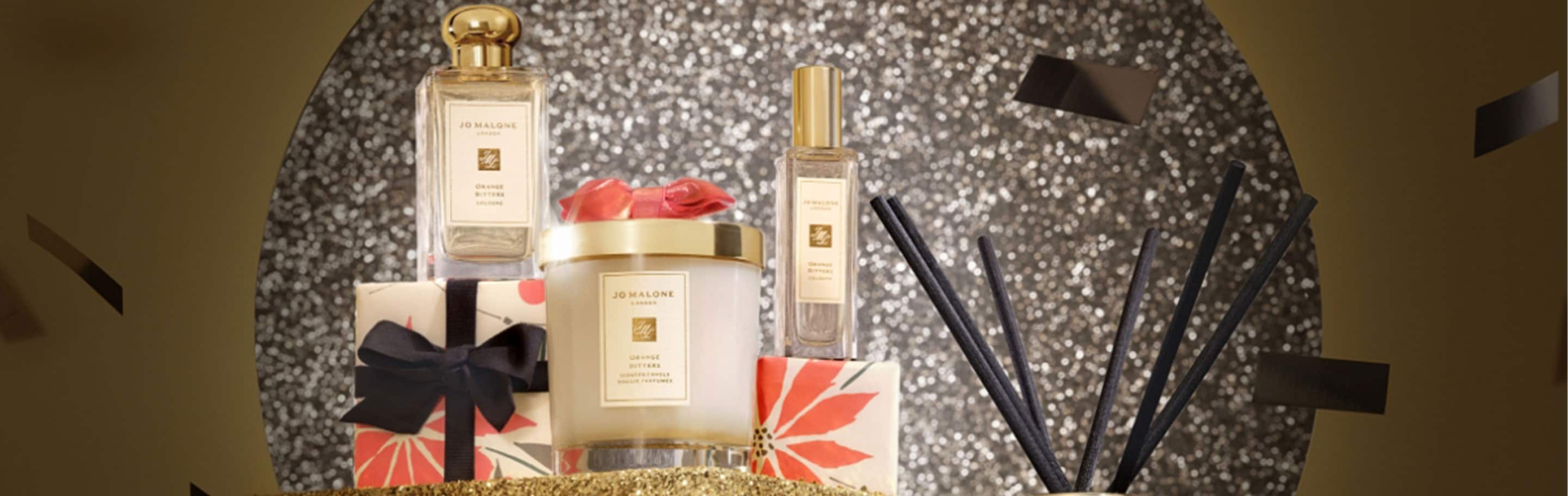 orange bitters 100ml cologne & home candle surrounded by snowballs and on a bed of white snow. 