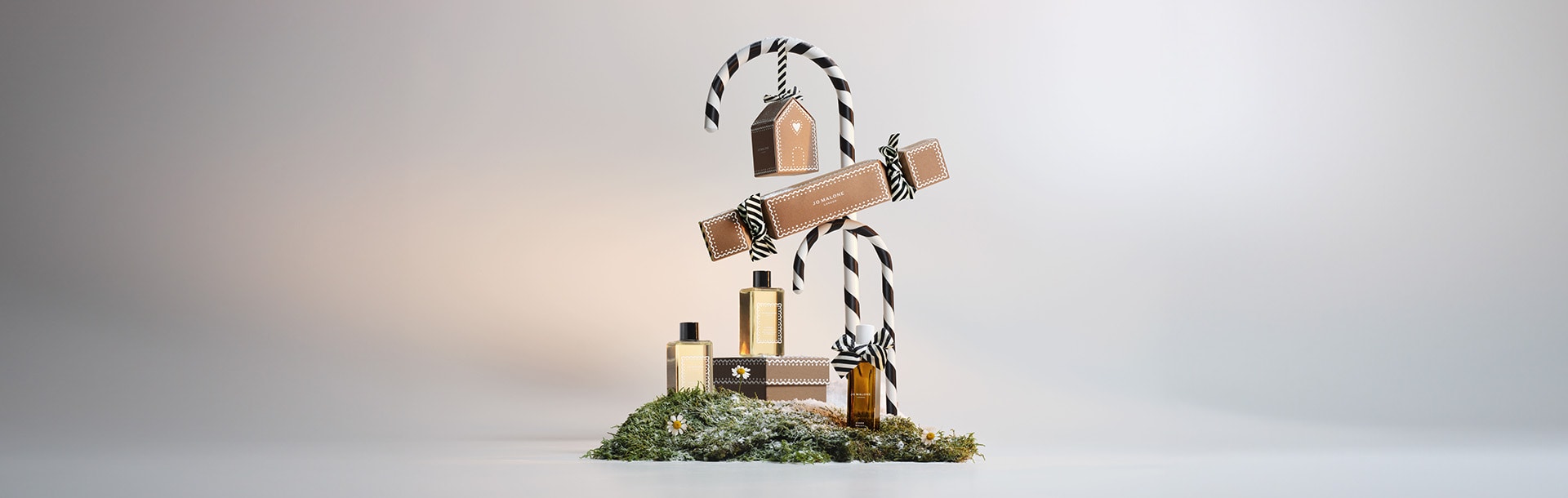 image of jo malone london boxes stacked with a miniature cologne, travel candle and travel size body cream
