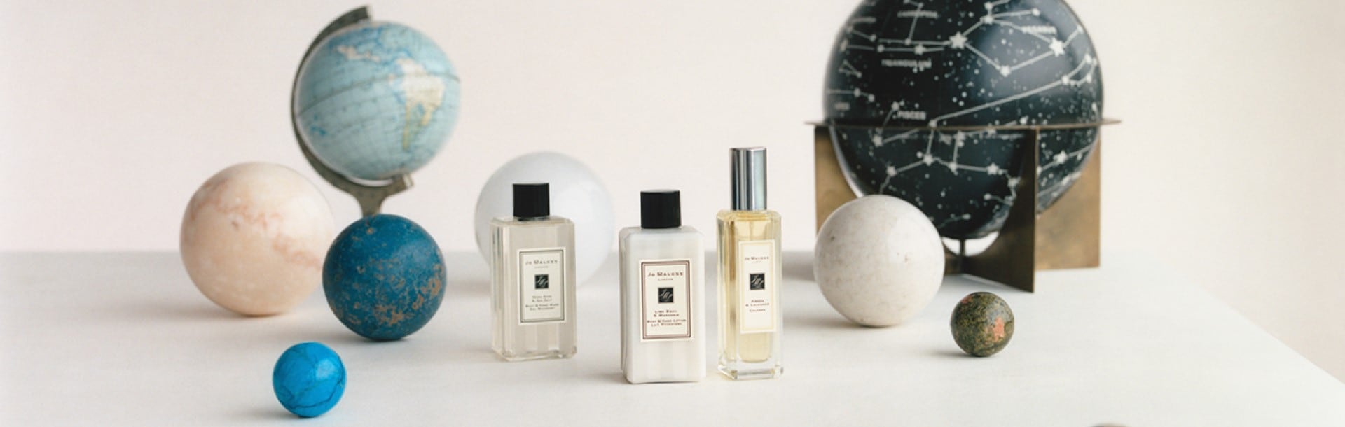 image of jo malone london boxes stacked with a miniature cologne, travel candle and travel size body cream